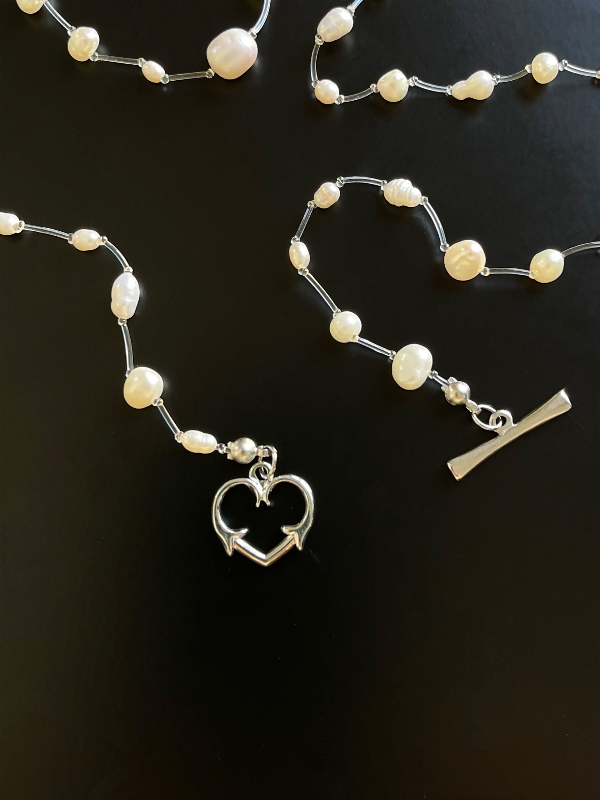 Beautiful white freshwater pearls, transparent thread and sterling steel heartshaped clasp