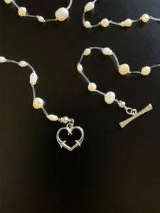Beautiful white freshwater pearls, transparent thread and sterling steel heartshaped clasp