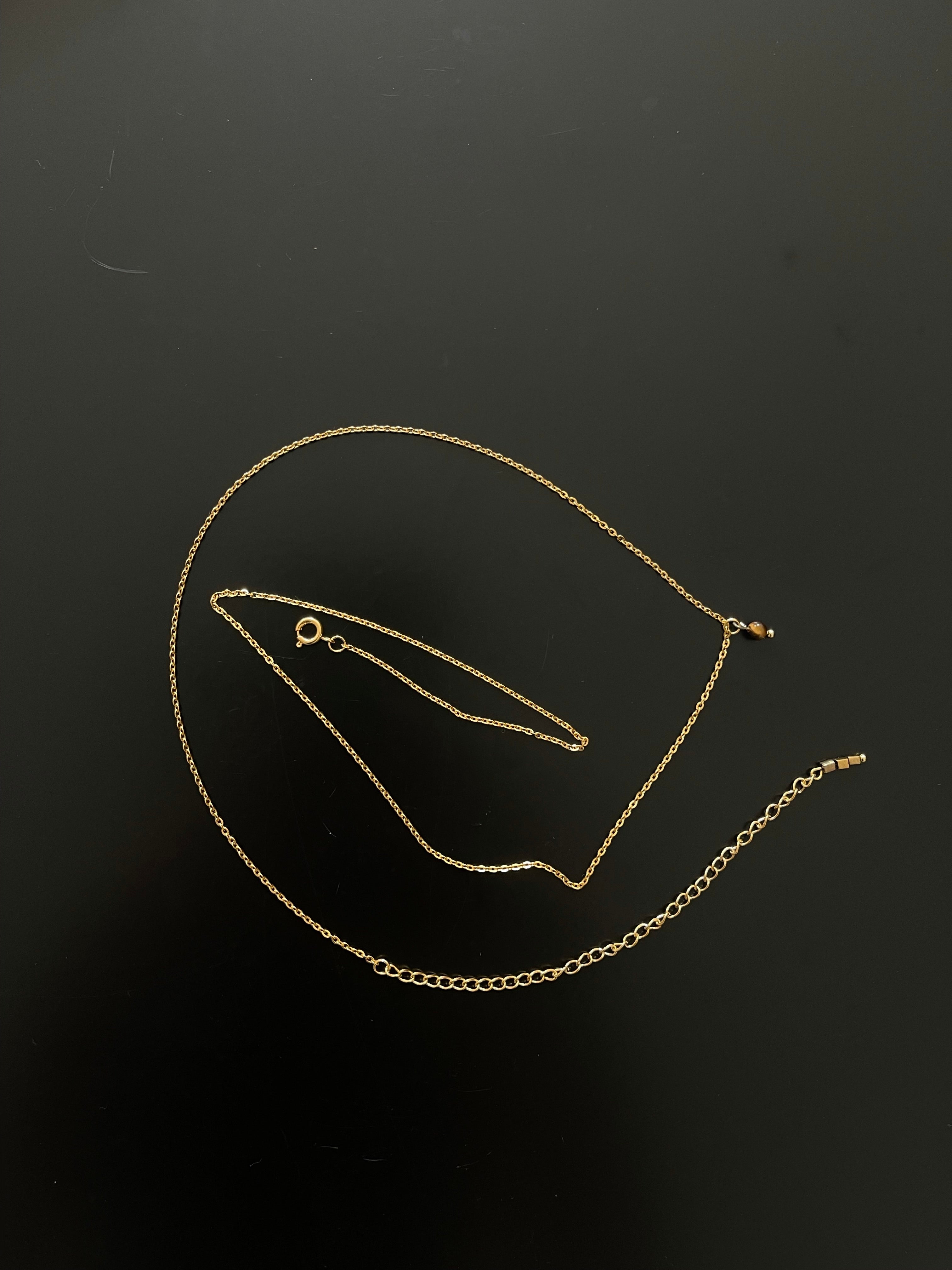 Gold body chain with tiger eye gemstone pendant.
